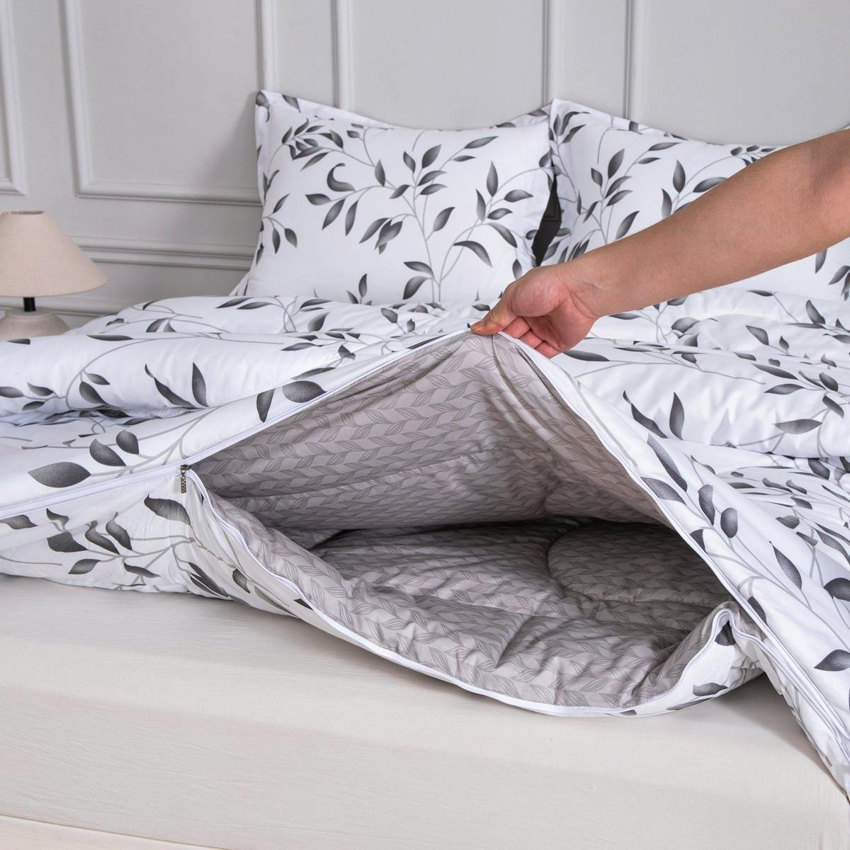 Een hand ritst de delen van vierseizoenen dekbed Nora aan elkaar, ideaal om de warmte eenvoudig aan te passen.