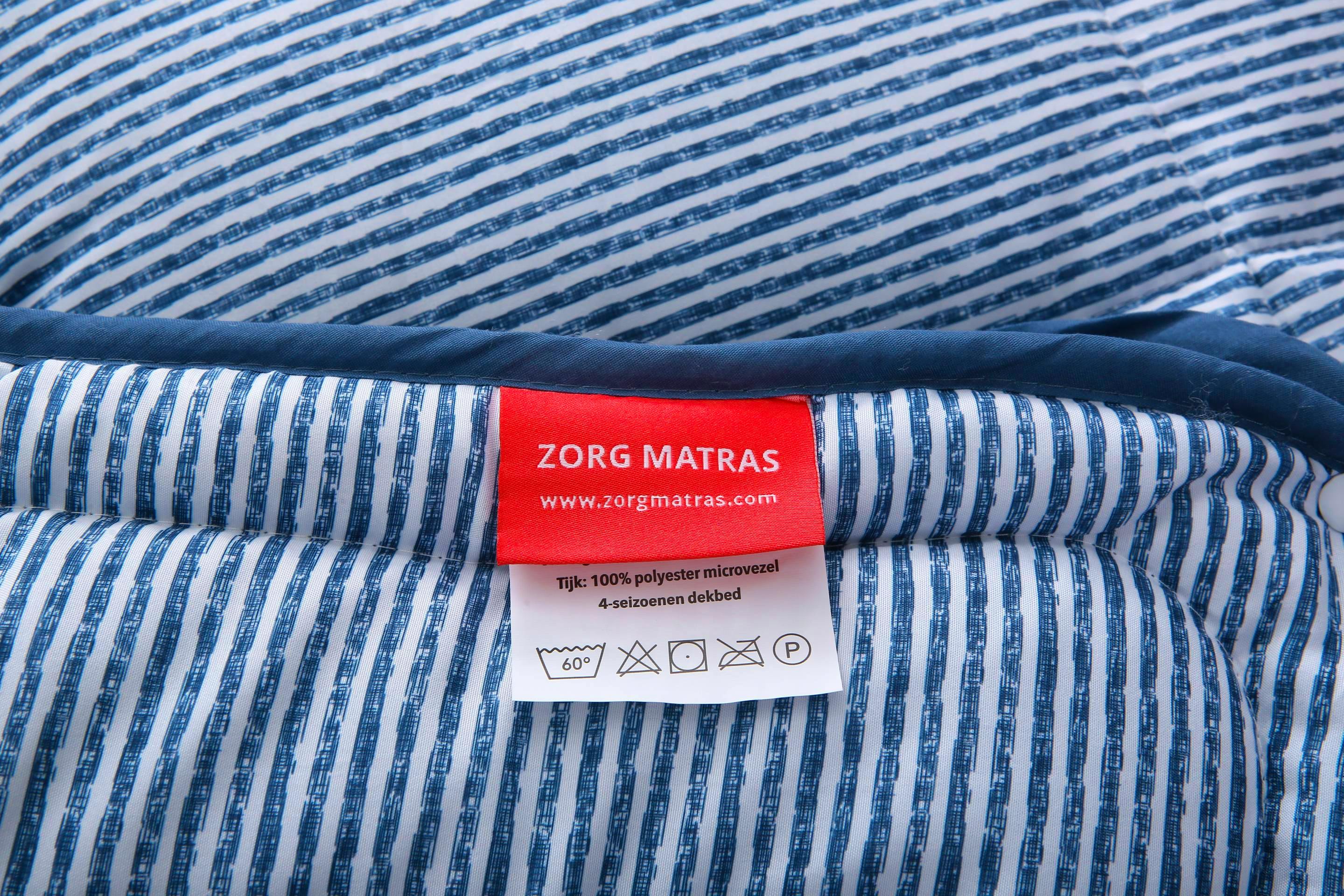 Rose label van Zorgmatras met wasvoorschriften op blauw-wit gestreept 4-seizoenen dekbed zonder overtrek – wasbaar op 60 graden en geschikt voor dagelijks gebruik