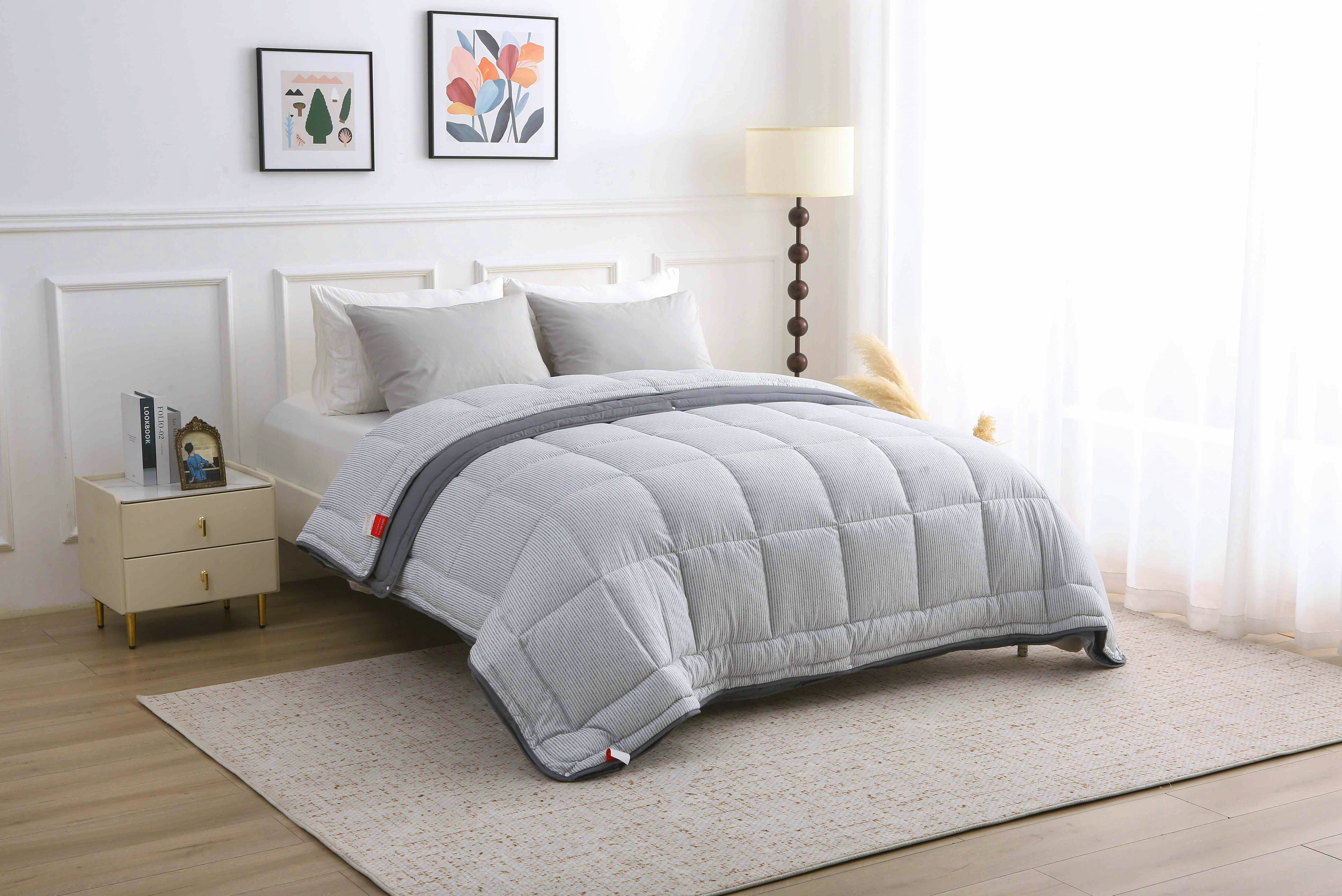 Tijdloze slaapkamer met lichtinval en een opgemaakt 4-seizoenen dekbed in grijs dessin zonder overtrek