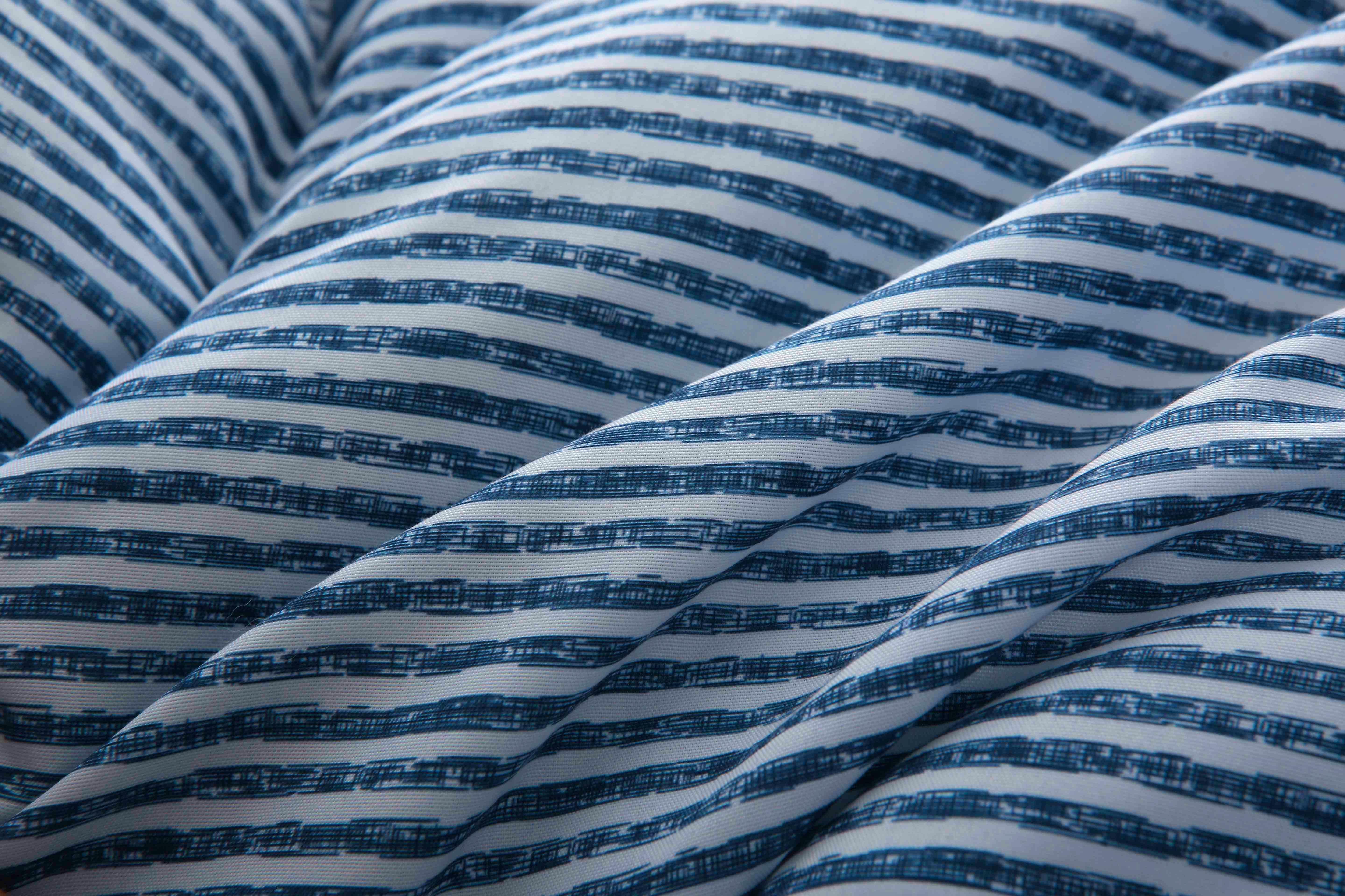 Close-up van de zachte, ademende microvezel tijk van het blauw-wit gestreepte 4-seizoenen dekbed zonder overtrek – huidvriendelijk en sneldrogend