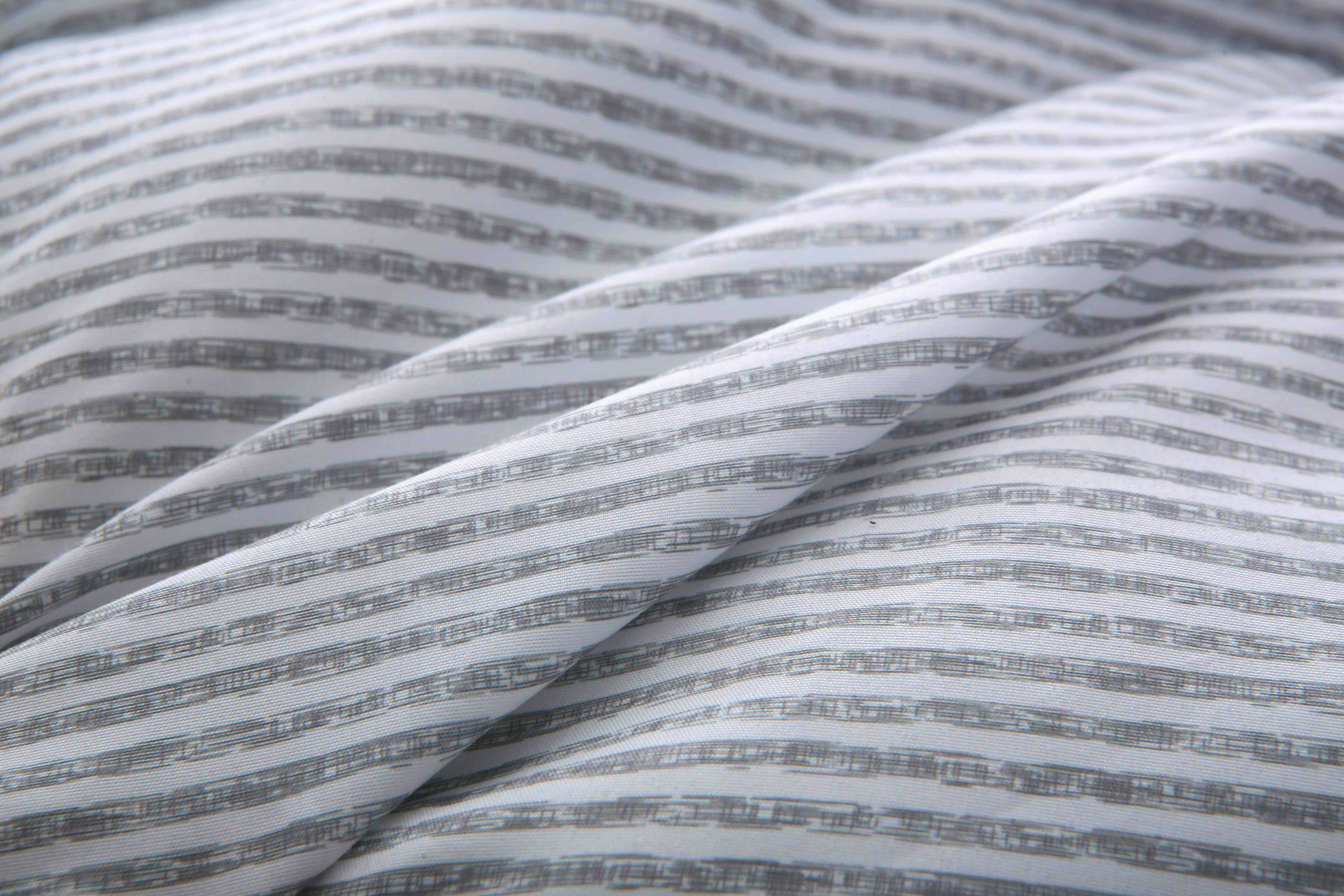 Close-up van de zachte tijkstof met strependessin van het 4-seizoenen dekbed